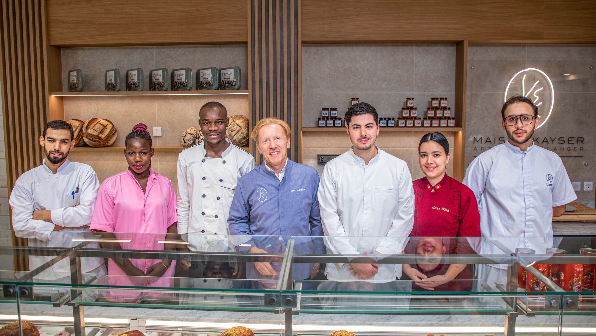 Maison Kayser team and guests beside the pastry display in Ouagadougou